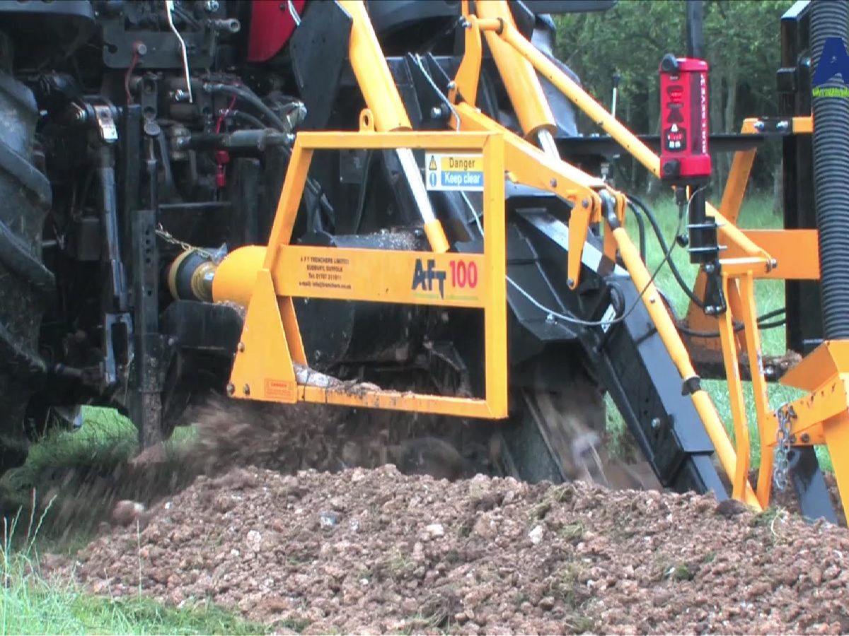 AFT 100 Kettengrabenfräse am Traktor verlegt Drainage und verfüllt mit Kies